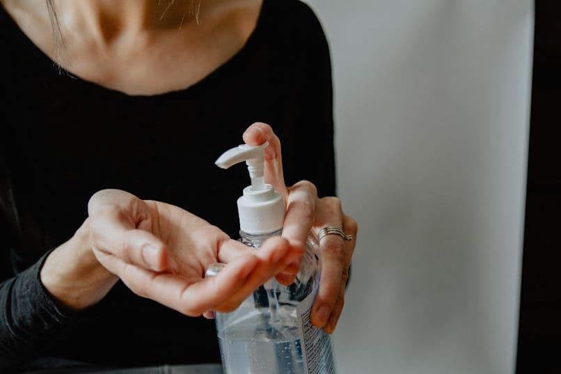 Hand using sanitizer bottle